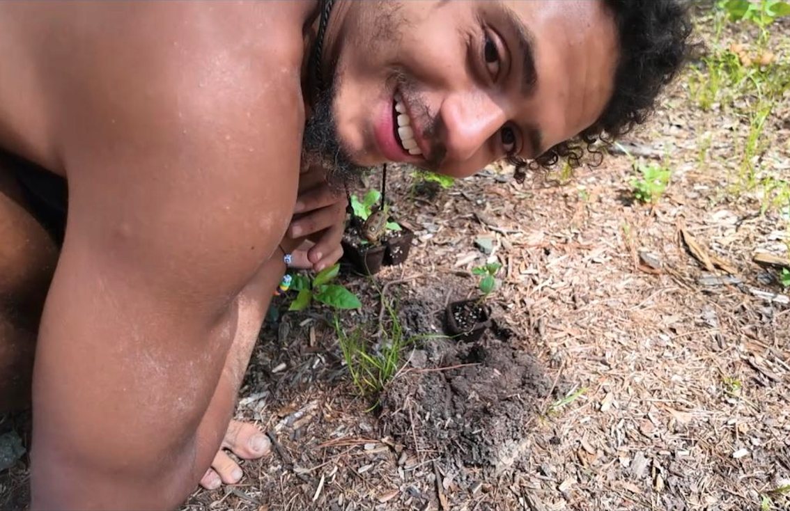 Taiyo smiling beside a freshly planted seedling